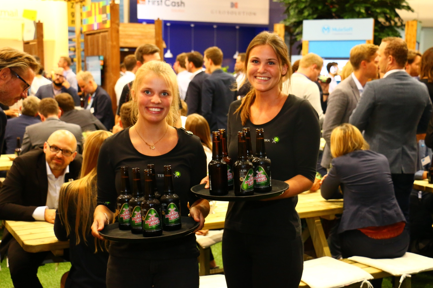 Catering-Service Schimion, Frauen halten das Tablett mit den Weinflaschen